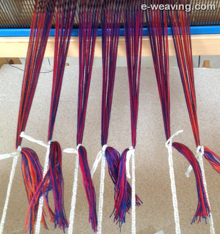 Tying onto warp beam stick with texsolv or loops with larkshead knots.